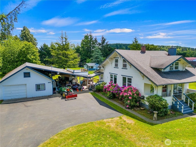 2520 Eureka Ave, Centralia, WA 98531 - view of front facade with asphalt driveway, a front lawn, a chimney, a shingled roof, and covered porch