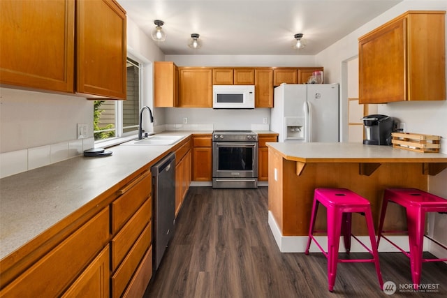 5542 55th Loop SE, Olympia, WA 98513 - kitchen featuring stainless steel appliances, dark wood-style flooring, light countertops, and a peninsula