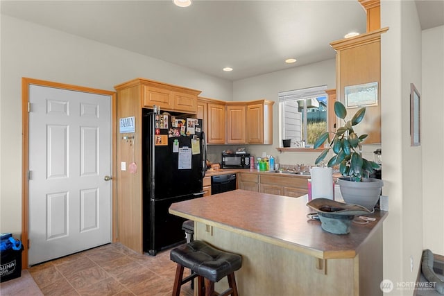 2599 NW Columbia Ave, East Wenatchee, WA 98802 - kitchen featuring black appliances, a peninsula, light brown cabinets, a kitchen breakfast bar, and recessed lighting
