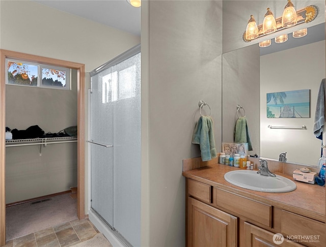 2599 NW Columbia Ave, East Wenatchee, WA 98802 - bathroom featuring a stall shower, vanity, and a walk in closet