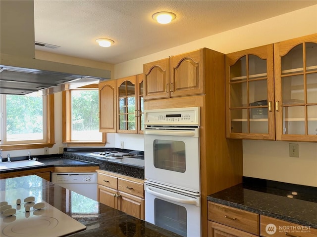 832 Whale Ct SW, Ocean Shores, WA 98569 - kitchen featuring white appliances, glass insert cabinets, brown cabinetry, dark stone counters, and a textured ceiling
