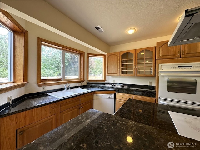 832 Whale Ct SW, Ocean Shores, WA 98569 - kitchen featuring white appliances, extractor fan, glass insert cabinets, a textured ceiling, and brown cabinets