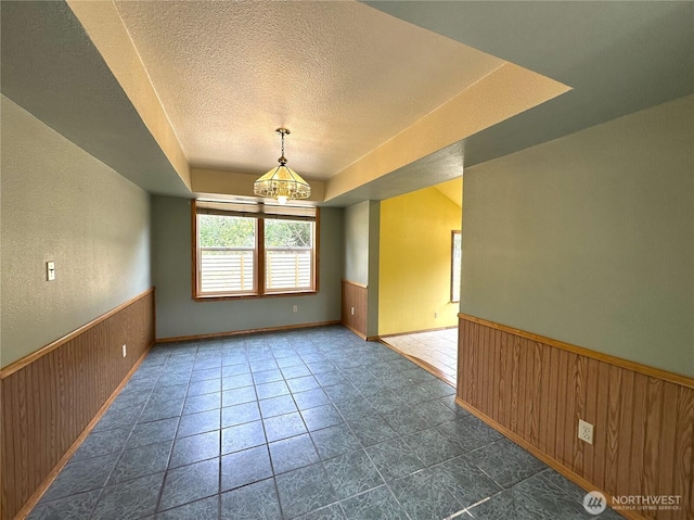 832 Whale Ct SW, Ocean Shores, WA 98569 - empty room featuring a textured ceiling, a wainscoted wall, and wood walls