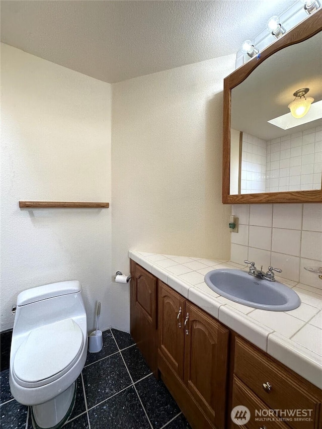 832 Whale Ct SW, Ocean Shores, WA 98569 - half bath featuring vanity, backsplash, and tile patterned flooring