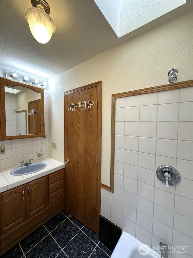 832 Whale Ct SW, Ocean Shores, WA 98569 - full bathroom with vanity, decorative backsplash, and a skylight