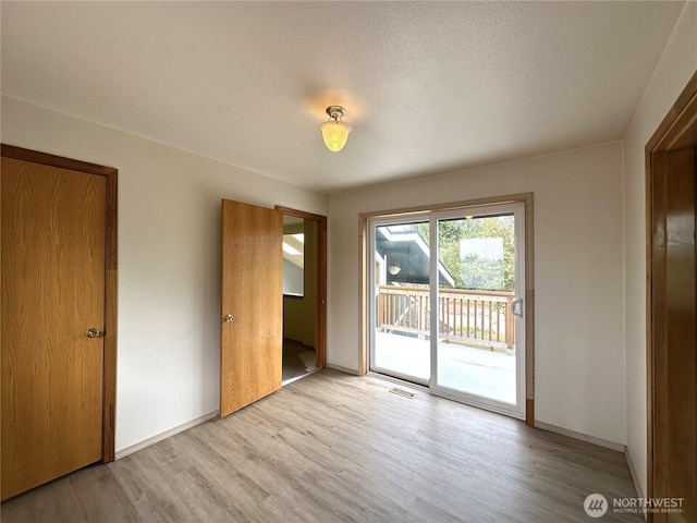 832 Whale Ct SW, Ocean Shores, WA 98569 - unfurnished bedroom with light wood-style floors and access to exterior