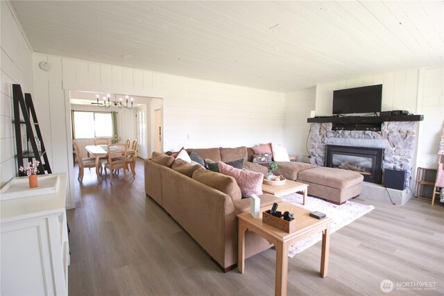 251 N 2nd St N, Buckley, WA 98321 - living area with light wood-style floors, a chandelier, a fireplace, wood ceiling, and wooden walls