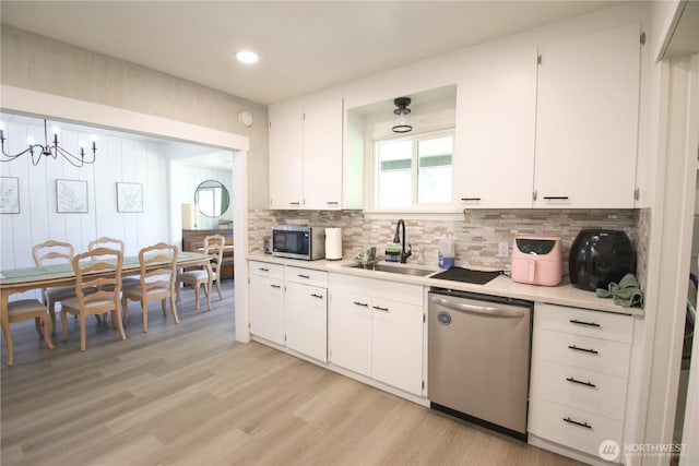 251 N 2nd St N, Buckley, WA 98321 - kitchen featuring appliances with stainless steel finishes, light countertops, tasteful backsplash, light wood-style flooring, and white cabinets