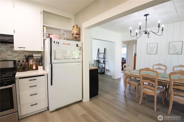 251 N 2nd St N, Buckley, WA 98321 - kitchen with freestanding refrigerator, electric range, light wood-type flooring, light countertops, and wooden walls