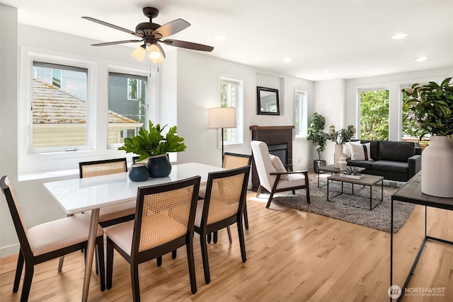 4220 Fremont Ave N Unit A, Seattle, WA 98103 - dining space with light wood-style floors, recessed lighting, a ceiling fan, and a glass covered fireplace