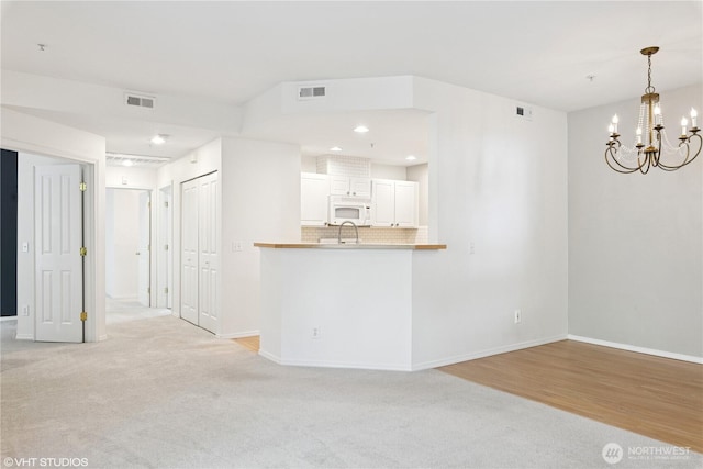 23757 SE 52nd Ln Unit 13-1, Issaquah, WA 98029 - unfurnished living room with a chandelier, light carpet, recessed lighting, and light wood-type flooring