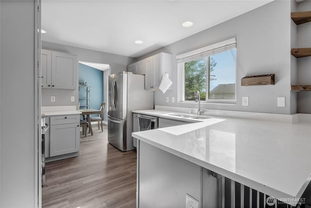 21812 41st Avenue Ct E, Spanaway, WA 98387 - kitchen featuring stainless steel fridge, light countertops, a peninsula, recessed lighting, and wood finished floors