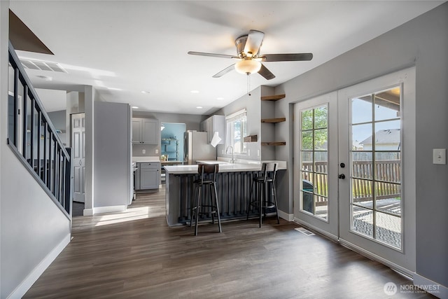 21812 41st Avenue Ct E, Spanaway, WA 98387 - kitchen featuring freestanding refrigerator, gray cabinets, light countertops, a kitchen bar, and a peninsula