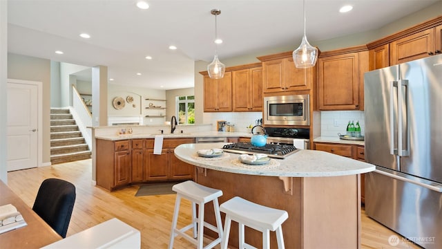 4597 Rutherford Cir SW, Port Orchard, WA 98367 - kitchen featuring stainless steel appliances, brown cabinets, a center island, light wood finished floors, and recessed lighting