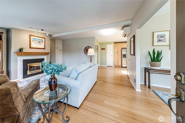 629 N 7th Ave, Sequim, WA 98382 - living area featuring a wall mounted air conditioner, light wood finished floors, a tiled fireplace, and rail lighting