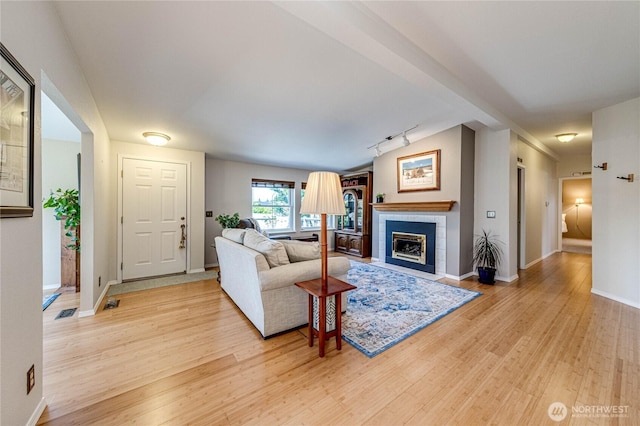 629 N 7th Ave, Sequim, WA 98382 - living room featuring light wood-type flooring, a tiled fireplace, and track lighting