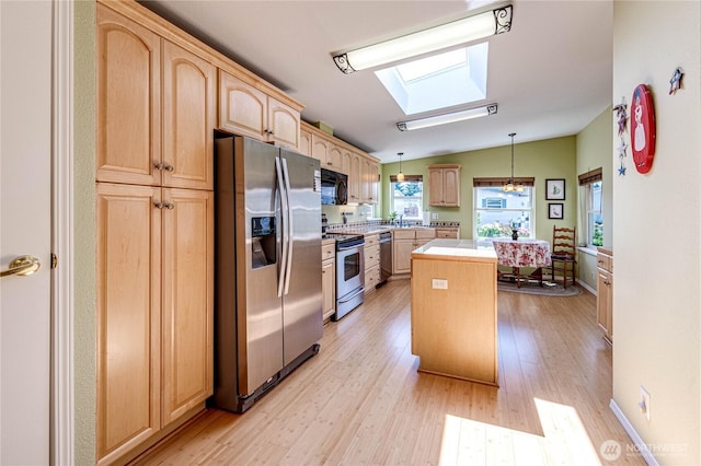 629 N 7th Ave, Sequim, WA 98382 - kitchen featuring stainless steel appliances, light brown cabinets, a skylight, a center island, and light countertops