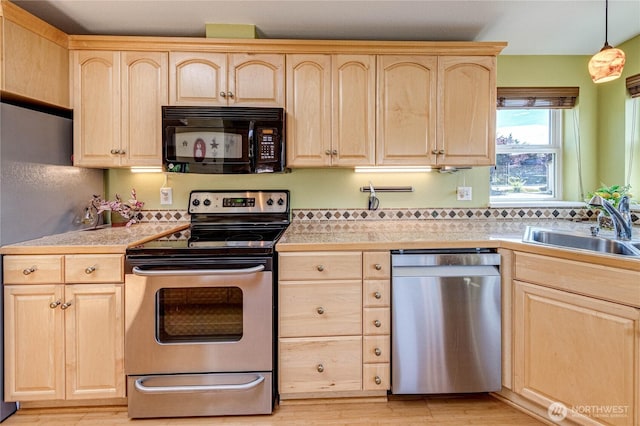 629 N 7th Ave, Sequim, WA 98382 - kitchen with stainless steel appliances, light brown cabinets, light wood-style flooring, and decorative light fixtures