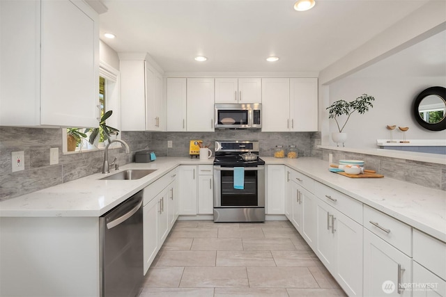 16011 Sunnyside Ave N, Shoreline, WA 98133 - kitchen with stainless steel appliances, white cabinets, light stone countertops, tasteful backsplash, and recessed lighting