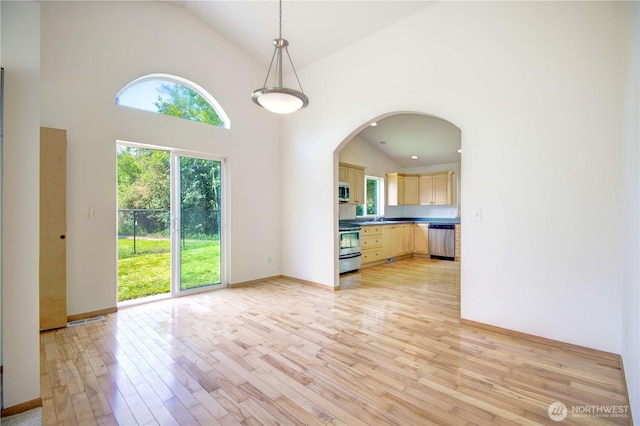 8391 Richmond Park Rd, Birch Bay, WA 98230 - unfurnished living room with light wood finished floors, high vaulted ceiling, and arched walkways
