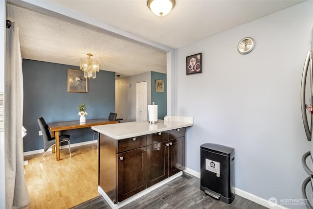 1938 66th Ave NE, Tacoma, WA 98422 - kitchen with dark wood finished floors, dark brown cabinets, light countertops, a chandelier, and a peninsula