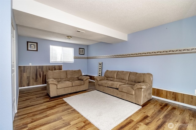 1938 66th Ave NE, Tacoma, WA 98422 - living room featuring light wood-style flooring, a textured ceiling, and wooden walls