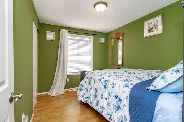 1938 66th Ave NE, Tacoma, WA 98422 - bedroom with wood finished floors, multiple windows, and a textured ceiling