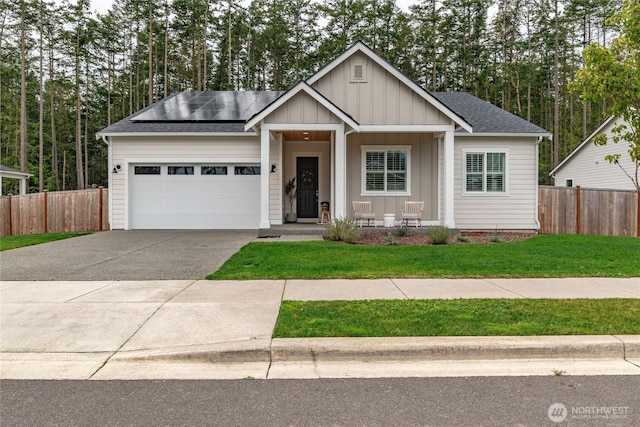 4561 Albatross St, Port Townsend, WA 98368 - view of front of property with a porch, roof mounted solar panels, a garage, concrete driveway, and board and batten siding