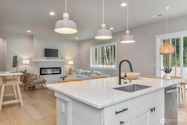 4561 Albatross St, Port Townsend, WA 98368 - kitchen with stainless steel dishwasher, light wood finished floors, recessed lighting, hanging light fixtures, and white cabinets