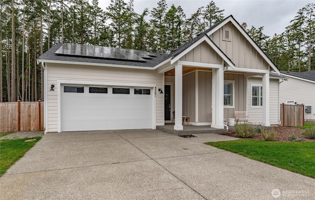 4561 Albatross St, Port Townsend, WA 98368 - view of front of house featuring board and batten siding, concrete driveway, roof mounted solar panels, and an attached garage