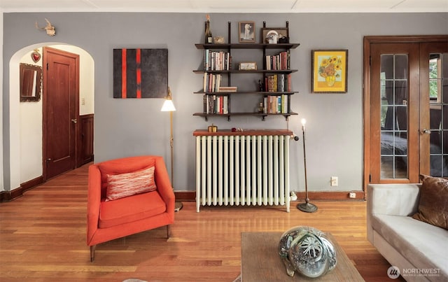 408 Bellevue Ave E Unit 306, Seattle, WA 98102 - living area featuring radiator, wood finished floors, and arched walkways