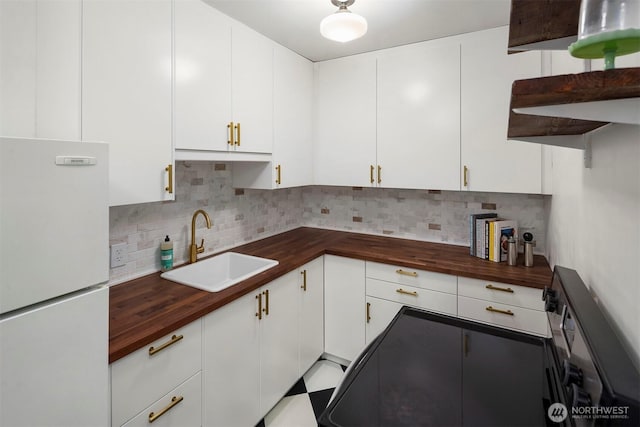 408 Bellevue Ave E Unit 306, Seattle, WA 98102 - kitchen with freestanding refrigerator, wooden counters, backsplash, and white cabinetry