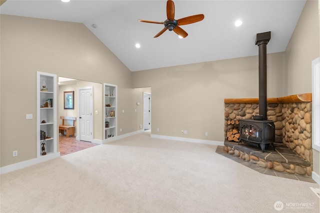 8012 105th Ave SW, Olympia, WA 98512 - unfurnished living room featuring a wood stove, ceiling fan, light colored carpet, high vaulted ceiling, and built in features