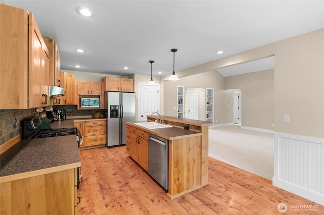 8012 105th Ave SW, Olympia, WA 98512 - kitchen with appliances with stainless steel finishes, dark countertops, under cabinet range hood, decorative backsplash, and an island with sink