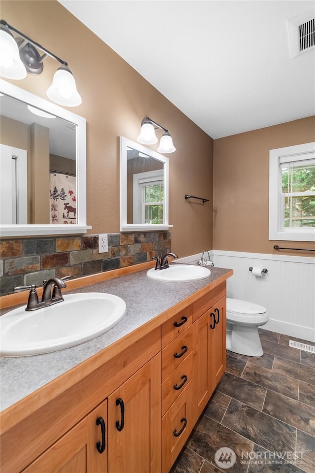 8012 105th Ave SW, Olympia, WA 98512 - full bathroom featuring double vanity, wainscoting, and stone finish floors