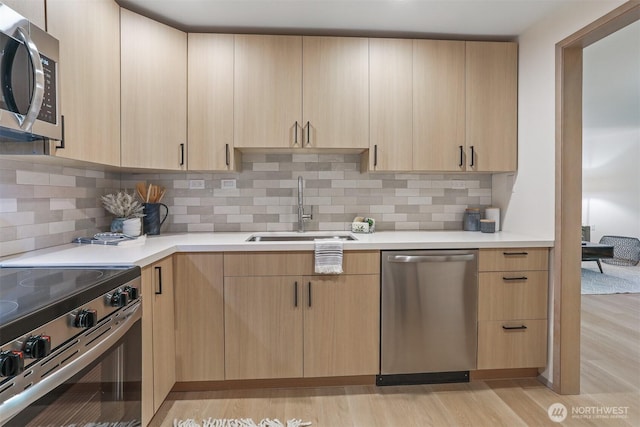 1100 E Harrison St Unit 103, Seattle, WA 98102 - kitchen featuring stainless steel appliances, light brown cabinetry, light countertops, and light wood-type flooring