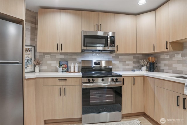 1100 E Harrison St Unit 103, Seattle, WA 98102 - kitchen featuring appliances with stainless steel finishes, light brown cabinets, light countertops, and tasteful backsplash