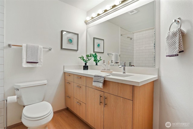 1100 E Harrison St Unit 103, Seattle, WA 98102 - bathroom with vanity, tiled shower, and wood finished floors