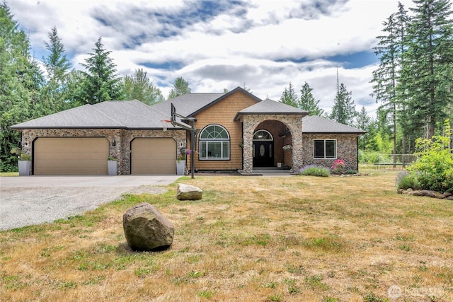 15949 159th Ln SE, Yelm, WA 98597 - view of front of house with gravel driveway, an attached garage, and stone siding