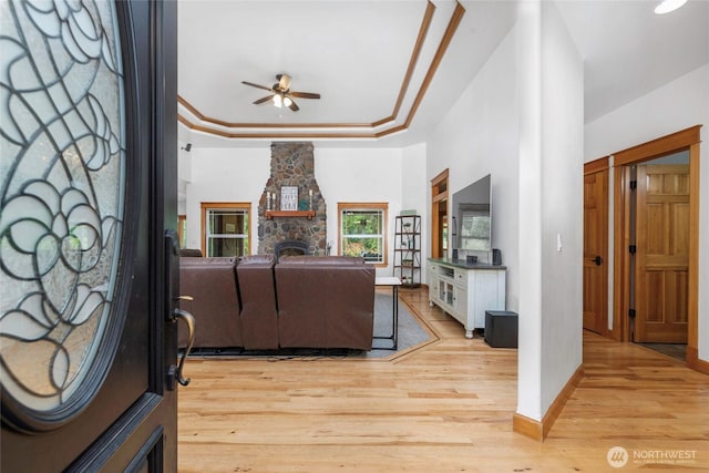 15949 159th Ln SE, Yelm, WA 98597 - living area with a ceiling fan, light wood-style flooring, a stone fireplace, and a tray ceiling