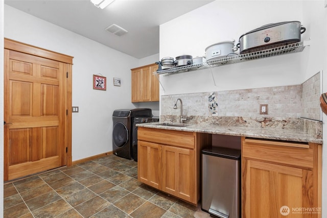 15949 159th Ln SE, Yelm, WA 98597 - kitchen featuring decorative backsplash, washing machine and clothes dryer, light stone countertops, and dark stone finish floors