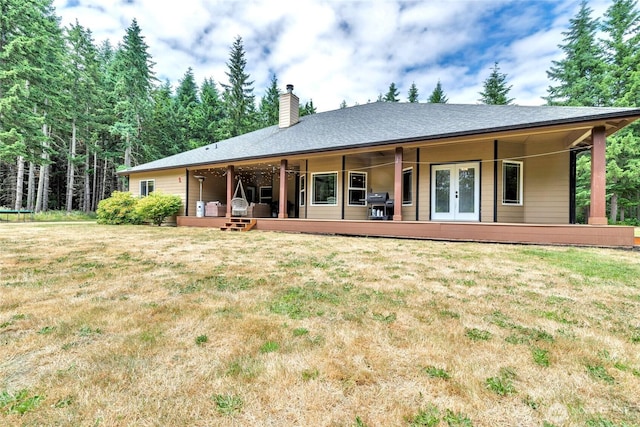 15949 159th Ln SE, Yelm, WA 98597 - rear view of house featuring a chimney, a yard, french doors, and a wooden deck