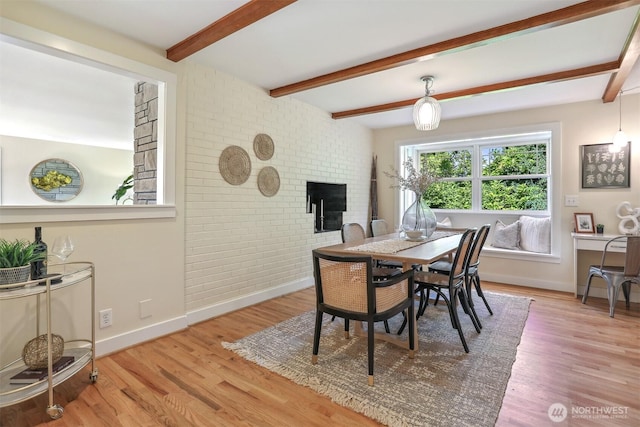 10718 12th Ave NW, Seattle, WA 98177 - dining room featuring beam ceiling, wood finished floors, a fireplace, and brick wall