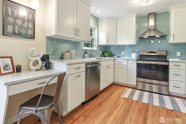 10718 12th Ave NW, Seattle, WA 98177 - kitchen with appliances with stainless steel finishes, wall chimney exhaust hood, light countertops, light wood-type flooring, and tasteful backsplash