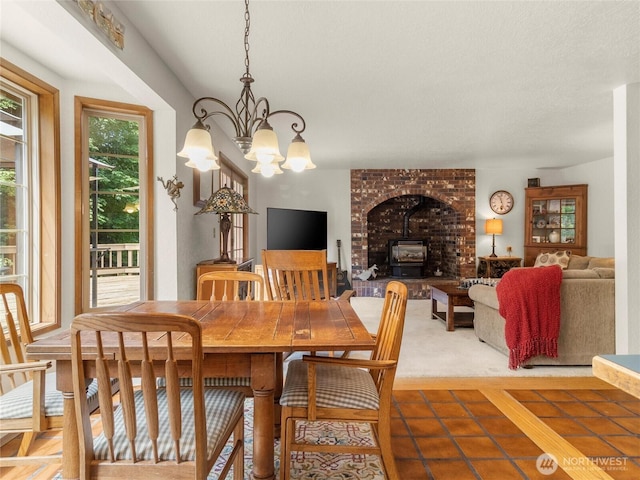 7842 Delphi Rd SW, Olympia, WA 98512 - tiled dining room featuring a wood stove and a chandelier
