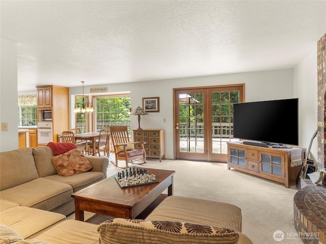 7842 Delphi Rd SW, Olympia, WA 98512 - living room featuring light carpet, a textured ceiling, a chandelier, and french doors