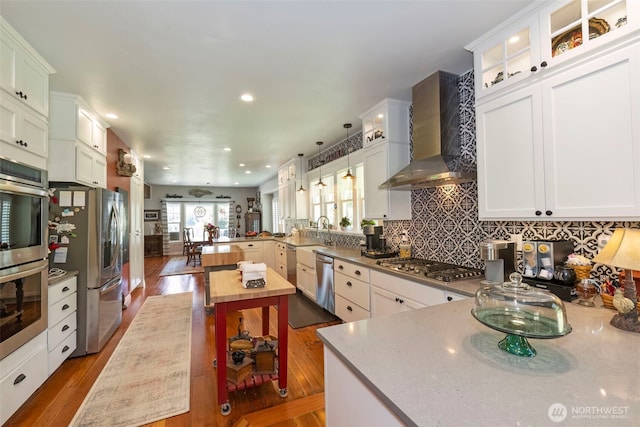 281 Jarvis Rd, Mossyrock, WA 98564 - kitchen featuring wall chimney exhaust hood, stainless steel appliances, a peninsula, wood finished floors, and glass insert cabinets
