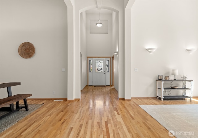 18130 Sunrise Ridge Ave NE, Poulsbo, WA 98370 - entrance foyer featuring arched walkways, a high ceiling, and light wood-style floors