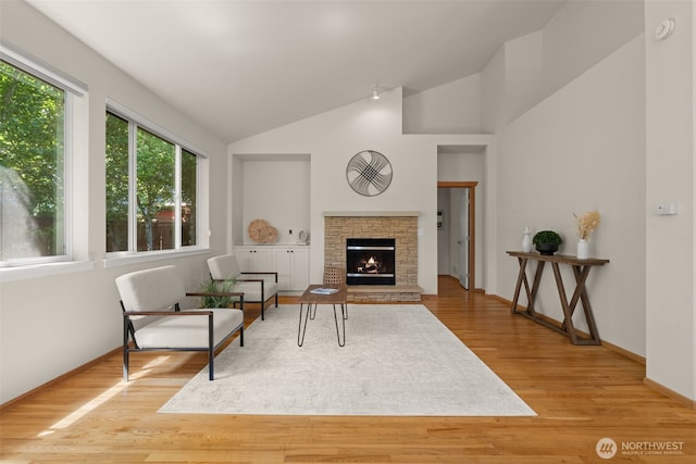 18130 Sunrise Ridge Ave NE, Poulsbo, WA 98370 - living room with vaulted ceiling, wood finished floors, and a lit fireplace