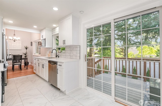14249 NE 1st St, Bellevue, WA 98007 - kitchen with appliances with stainless steel finishes, a chandelier, light countertops, white cabinetry, and tasteful backsplash